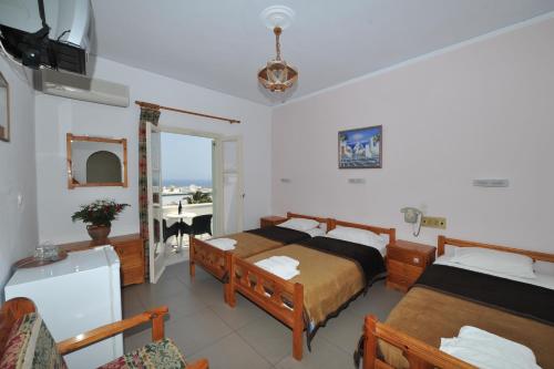 a bedroom with two beds and a balcony at Babis Hotel in Karterados