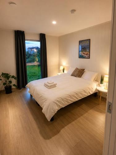 a bedroom with a large white bed and a window at Reine Sea Apartment in Moskenes