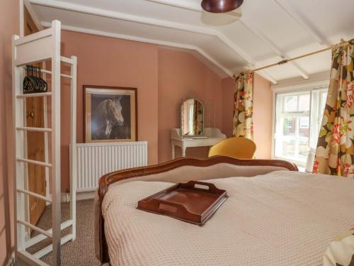 a bedroom with a bed with a tray on it at The Cooks Cottage in Malton