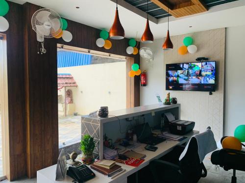 an office with a desk with a computer and a tv at MAHAMAYA CONVENTION and HOTEL in Mālatīpātpur