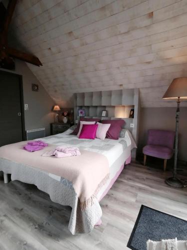 a bedroom with a large bed with pink pillows at Les Gites de Kerdurod in Guidel