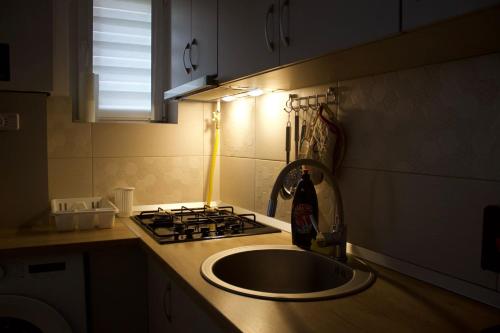 a kitchen counter with a sink and a stove at Natasa apartment in Băile Tuşnad