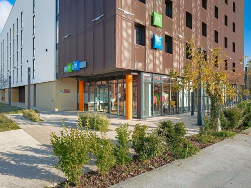 a building on a street with trees in front of it at ibis Styles La Rochelle Centre Gare in La Rochelle