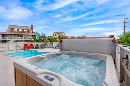 a jacuzzi tub on a patio next to a house at 6170 - Poolside Paradise in Nags Head