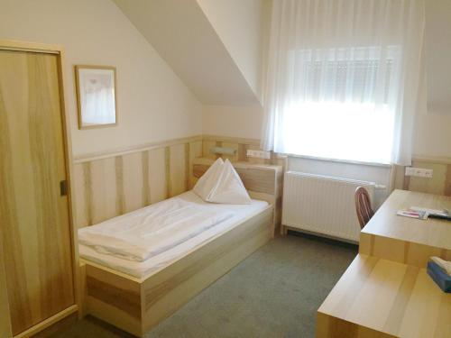 a small room with a bed and a window at Pension Weber in Vienna