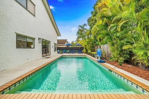 a swimming pool in front of a house at Pool - BBQ - Fire pit - Pool Table - TV room in Miami
