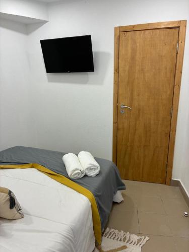 a bedroom with a bed and a wooden door at Casa Ducrate by Asterisco Secular in Crato