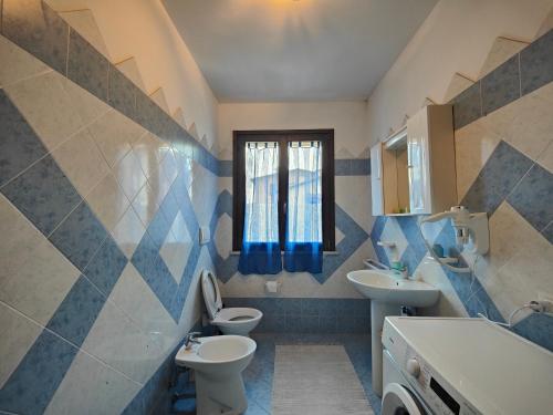a bathroom with two toilets and a sink and a window at Residence con Piscina Vista Monte Nerone in Piobbico