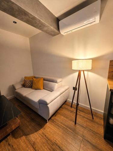 ein Wohnzimmer mit Sofa und Lampe in der Unterkunft Apartman Evelissima Brčko in Brčko