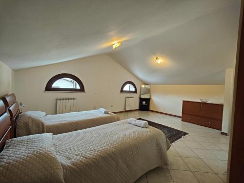 two beds in a room with two windows at Residence con Piscina Vista Monte Nerone in Piobbico