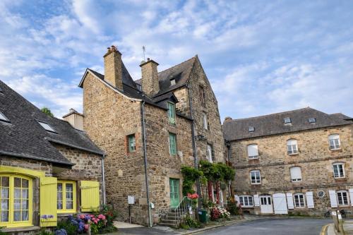 an old stone building with flowers in front of it at La Petite Madeleine is a Charming 2 Bedroom Pet Friendly Gite situated on Dinan Port in Dinan