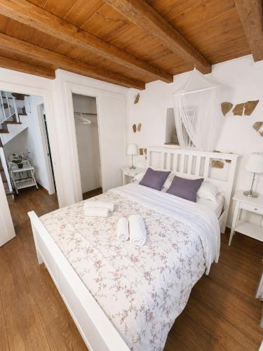 a white bedroom with a large bed with two pillows at La casa de Rodrigo y Manuela in Tarifa