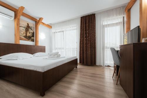 une chambre avec un grand lit et une télévision dans l'établissement Vila Victory, à 2 Mai