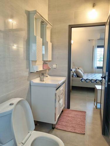 a bathroom with a toilet and a sink and a bed at Villa Bamba TERANGA in Somone