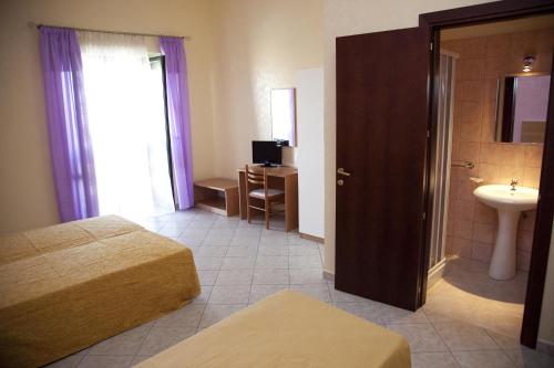 a hotel room with two beds and a sink at il portico dei normanni in Butera