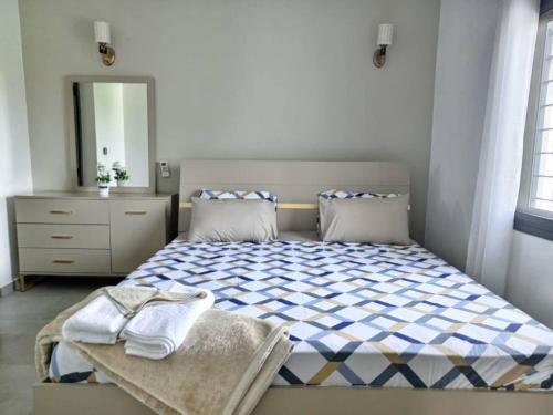 a bedroom with a bed and a dresser and a mirror at Villa Bamba TERANGA in Somone