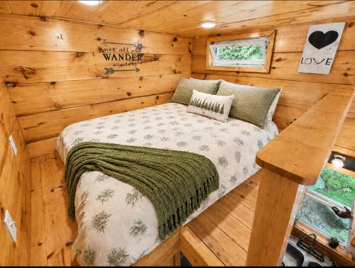 a bedroom in a wooden cabin with a bed at Peaceful Forest Tiny Home in Newport