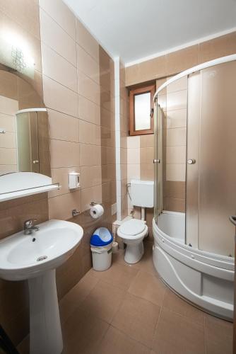 une salle de bains avec lavabo, toilettes et douche dans l'établissement Vila Victory, à 2 Mai