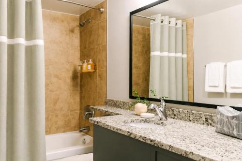 a bathroom with a sink and a tub and a mirror at Bluebird Suites at Georgetown in Washington, D.C.