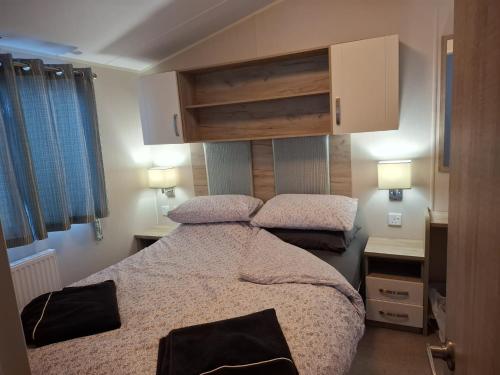 two beds in a small room with two lamps at The Cosy Nook in Launceston