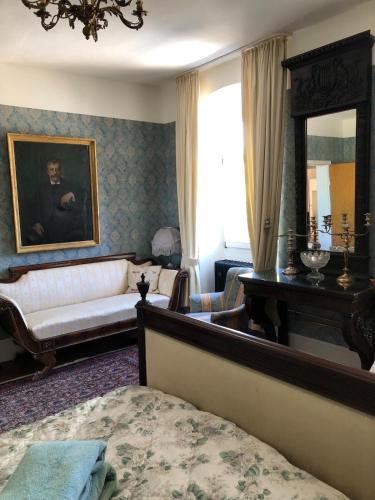 a living room with a bed and a mirror at Old Parish Hall, Waldeck Castle in Beltheim
