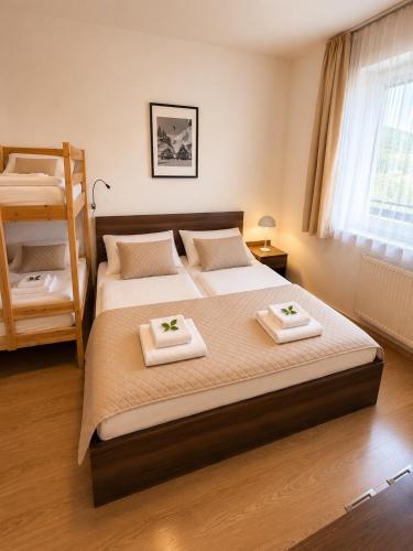a bedroom with two beds with towels on them at Ski IN-OUT Apartmán Donovaly in Donovaly