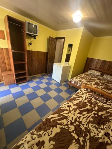 a room with two beds and a tiled floor at Дача in Kurortne