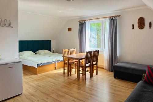 a room with a table and chairs and a bed at Pokoje Gościnne AKACJA in Swornegacie