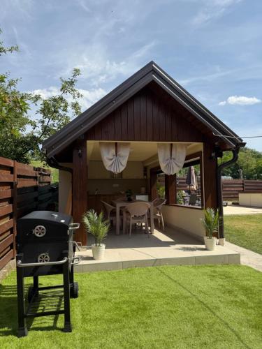 a gazebo with a grill in a yard at Vila Jovanovic in Bajina Bašta