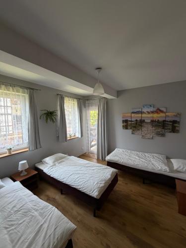 a bedroom with three beds in a room at Apartament pod Dębami in Rowy