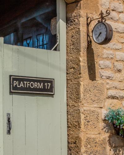 a clock on the side of a building with a sign at Platform 17 in Pickering