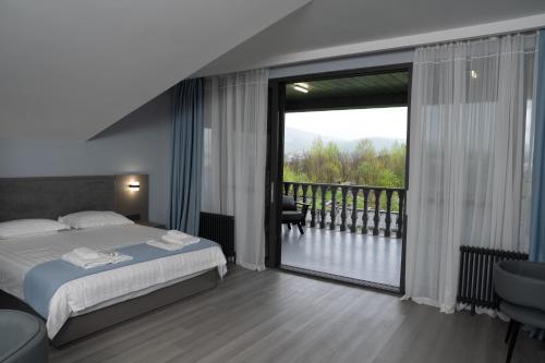 a bedroom with a bed and a balcony with a view at GRIG Villa & Hotel in Stepʼanavan