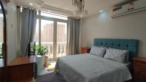 a bedroom with a bed and a large window at 378 Pyramids St -Two bedrooms Hotel Apartment in Cairo