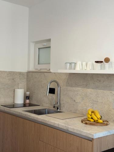 a kitchen with a sink and bananas on a counter at Apartments M&E in Mokošica
