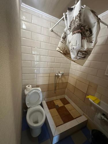 a small bathroom with a toilet and a towel at Дача in Kurortne