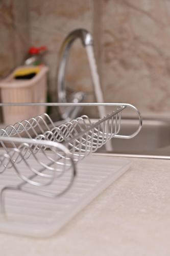 a dish drying rack sitting in a kitchen sink at Apartments Gajić with Private Free Parking - New & Modern in Bar