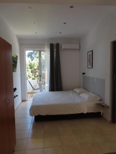 a bedroom with a bed and a sliding glass door at Forest Calm Faliraki in Faliraki