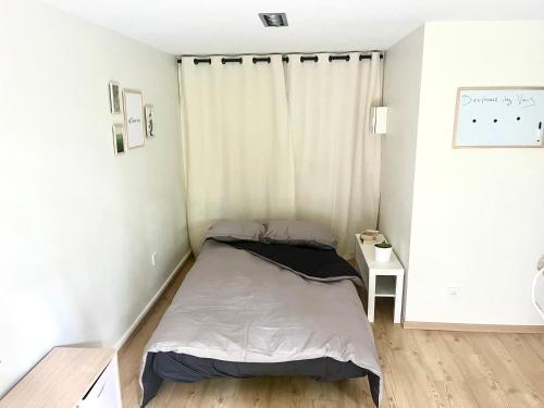 a small bedroom with a bed and a window at Le Studio nature de La Pra in Herbeys