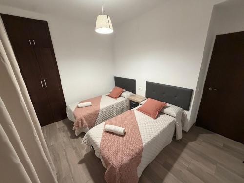 a room with two beds with pink and white blankets at Casa Javi y Carmen B Iz in Coto Ríos