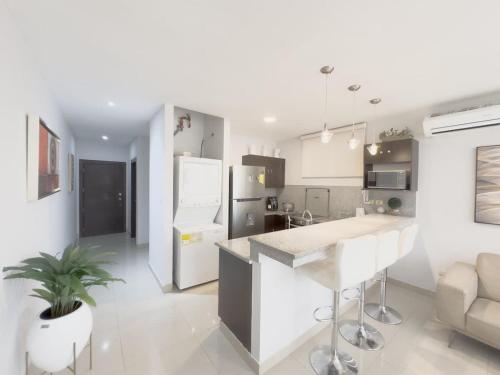 a white kitchen with a island in a room at Amazing apartment near US Consulate in Guayaquil