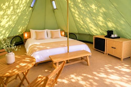 a bedroom with a bed in a green tent at La Ballenera Lodge in Guaquen