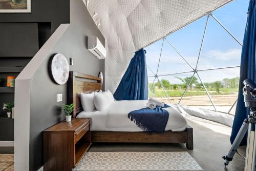 a bedroom with a bed and a large window at Stargazer Dome Retreat in San Marcos