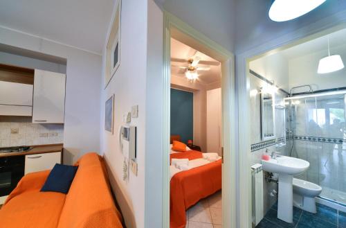a small bathroom with an orange bed and a sink at On The Beach in Mazzeo