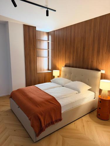 a bedroom with a large white bed with wooden walls at Street Apartment Rombon in Bovec