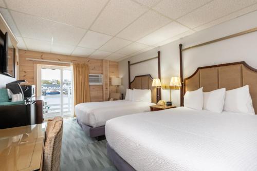 a hotel room with two beds and a television at Boothbay Harbor Inn in Boothbay Harbor