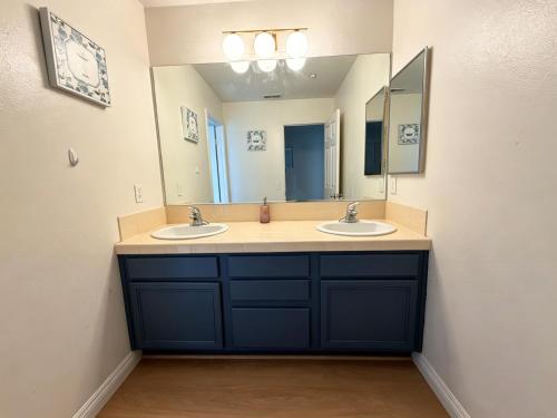 a bathroom with two sinks and a large mirror at Spacious Private Bedrooms With Full Amenities Near Grocery Stores & Main Highway Routes in Fontana