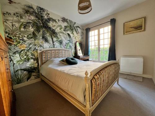 een slaapkamer met een bed met tropisch behang bij House with garden in Pérouges