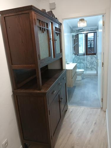 a bathroom with a large wooden cabinet with a mirror at Casa da Chelo 