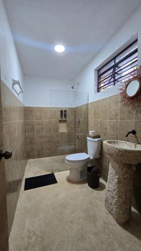 a bathroom with a toilet and a sink at Villa Carulio in Ebtún