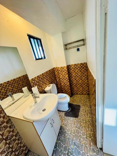 a bathroom with a sink and a toilet at Three bedroom apartment in Suva
